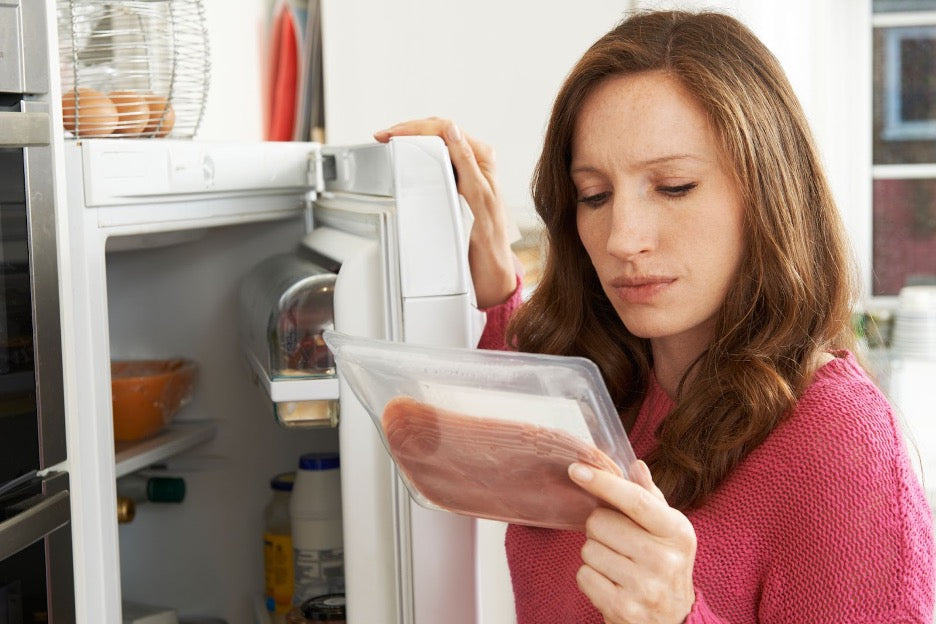 A person evaluating processed meat from the fridge.