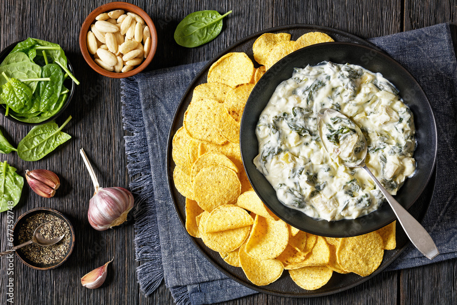 spinach dip in gray bowl on tray with chips